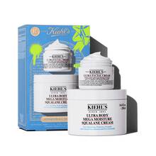 A graphic featuring a blue Kiehl’s gift box. The box contains two white jars: "KIEHL’S ULTRA FACIAL CREAM" and "KIEHL’S ULTRA BODY MEGA MOISTURE SQUALANE CREAM." The box has bright green graphic paint splatters and a bow design, and features the text "HYDRATION ALL THE WAY" on the front.